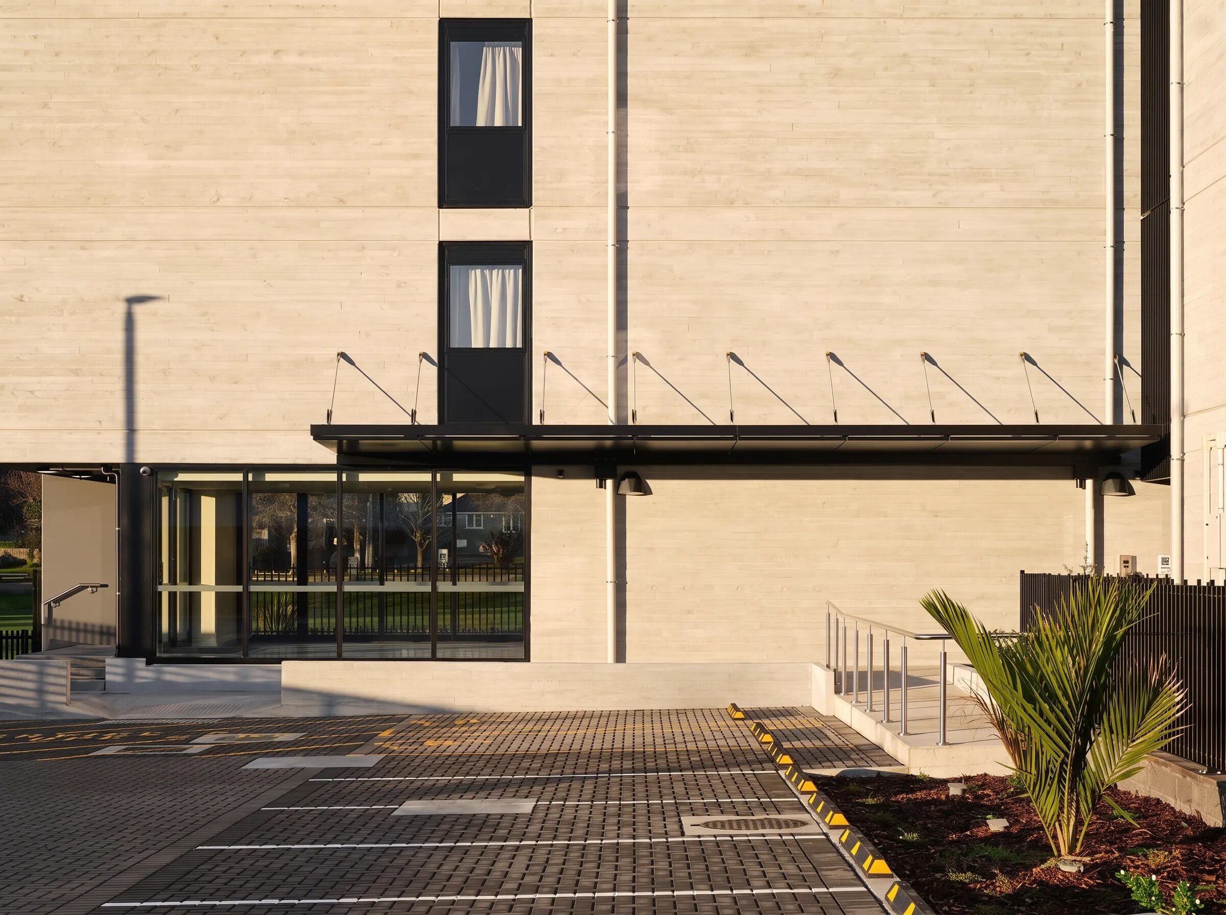 Entrada canopy over the entrance of a concrete building, with a paved path leading up to it
